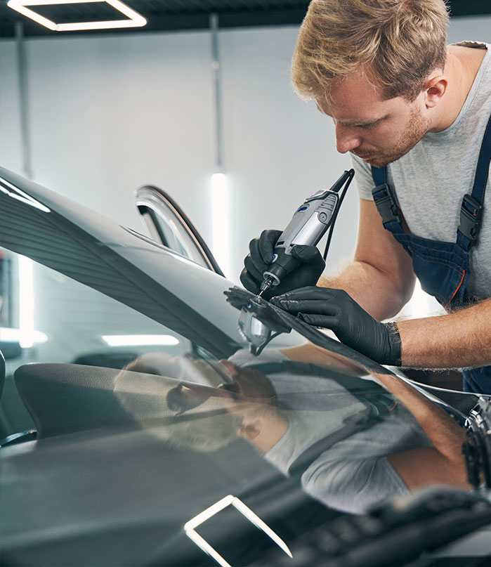 man-fixing-windshield - American Auto Glass Solutions